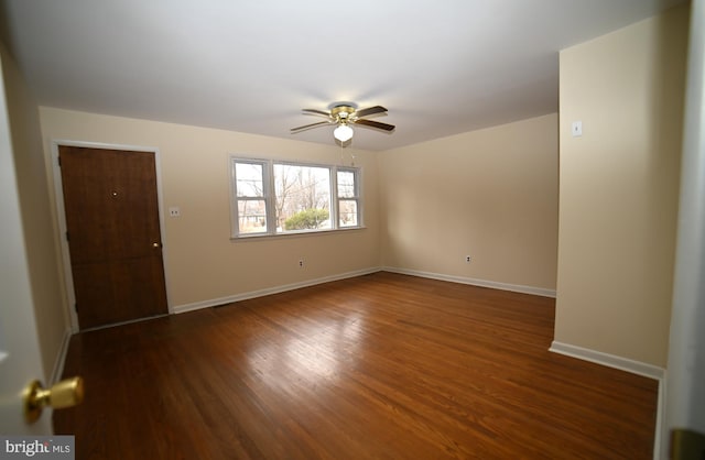 unfurnished room with dark wood-style floors, baseboards, and ceiling fan