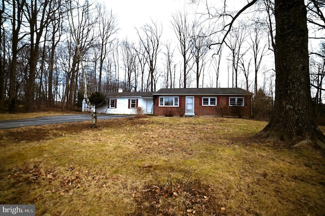 ranch-style home with a front lawn, brick siding, and driveway