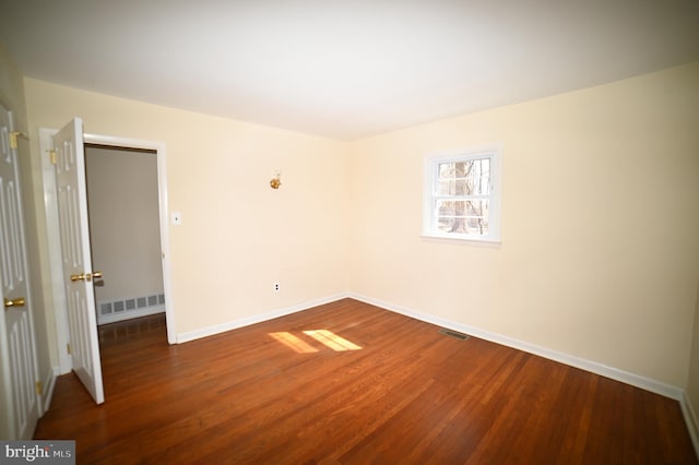 unfurnished bedroom featuring visible vents, baseboards, and wood finished floors