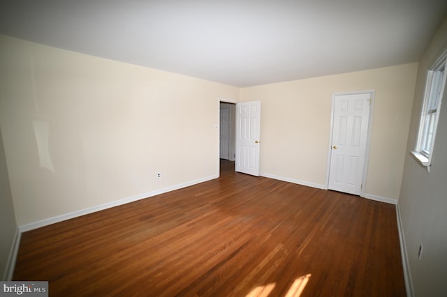 unfurnished bedroom featuring dark wood-style floors and baseboards