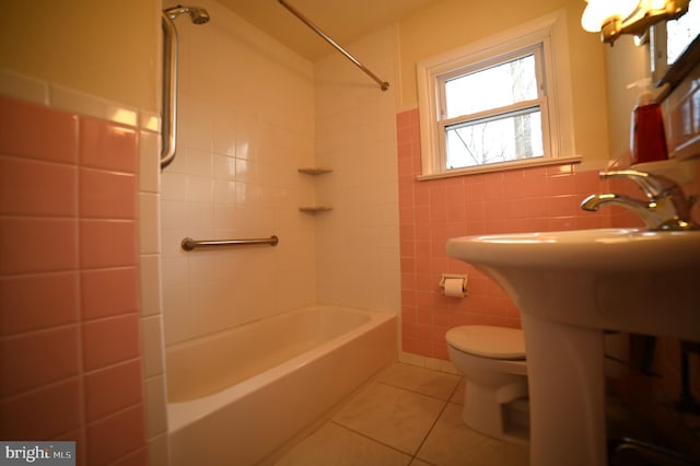 bathroom with bathtub / shower combination, tile patterned floors, toilet, and tile walls