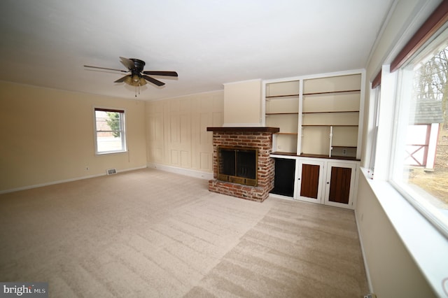 unfurnished living room featuring visible vents, a brick fireplace, baseboards, ceiling fan, and light carpet