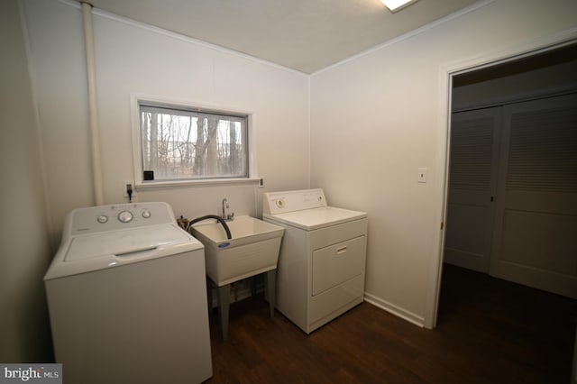 laundry room featuring dark wood-type flooring, ornamental molding, laundry area, washer and dryer, and a sink