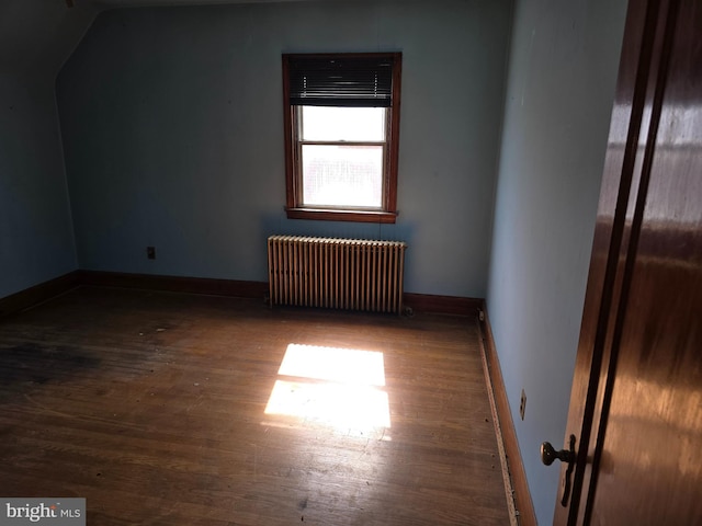 additional living space featuring radiator, baseboards, and wood finished floors