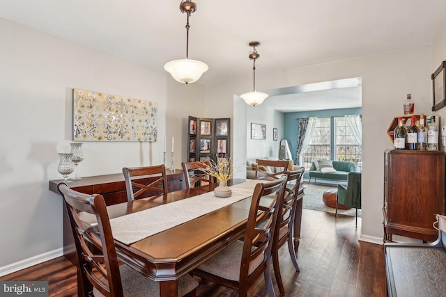 dining area featuring dark wood finished floors and baseboards