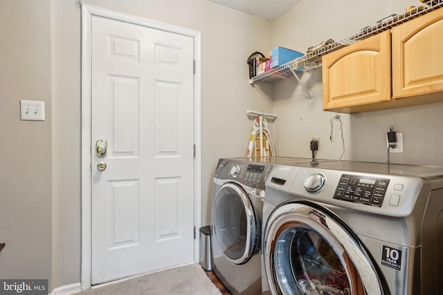 laundry room featuring washing machine and clothes dryer and cabinet space