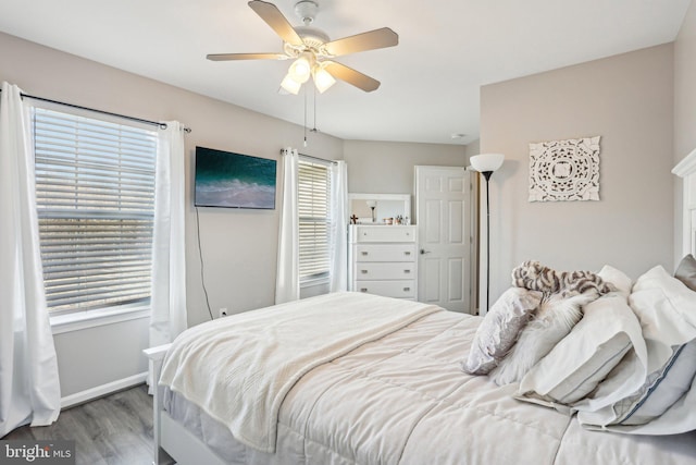 bedroom featuring baseboards, wood finished floors, and a ceiling fan