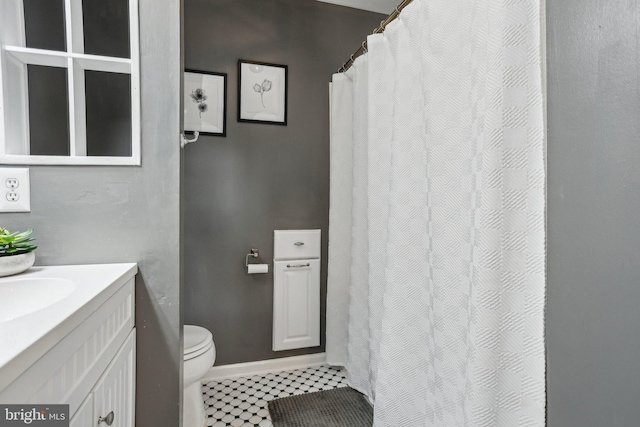 full bathroom featuring baseboards, toilet, and vanity