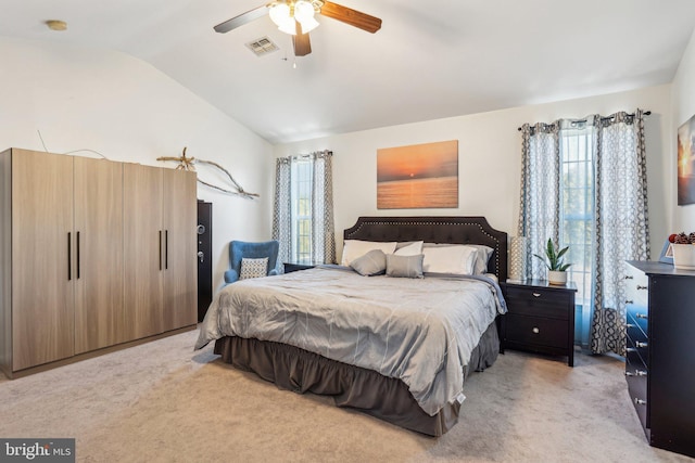 bedroom with visible vents, light colored carpet, a ceiling fan, and vaulted ceiling