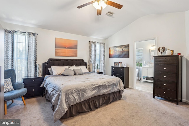 bedroom featuring visible vents, connected bathroom, carpet floors, lofted ceiling, and ceiling fan