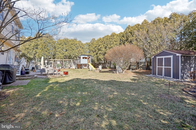 view of yard with fence, an outbuilding, and a shed