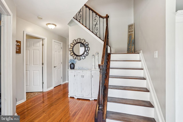 stairway featuring baseboards and wood finished floors