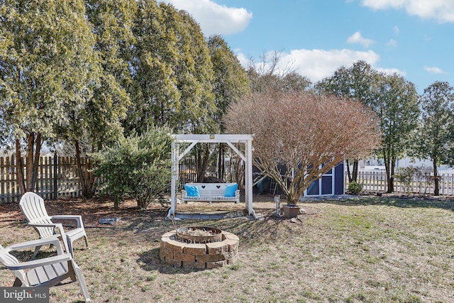 view of yard with fence and an outdoor fire pit