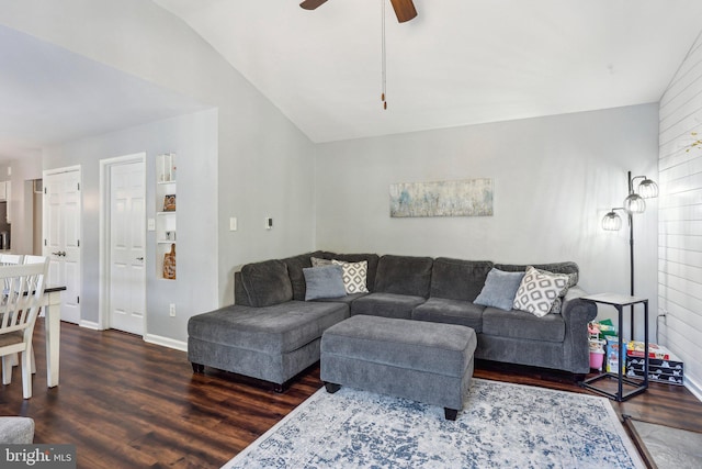 living area featuring vaulted ceiling, baseboards, ceiling fan, and wood finished floors