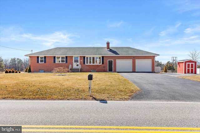 single story home featuring a shed, driveway, a front lawn, a garage, and brick siding