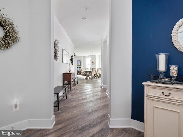 hallway featuring baseboards and dark wood-style flooring