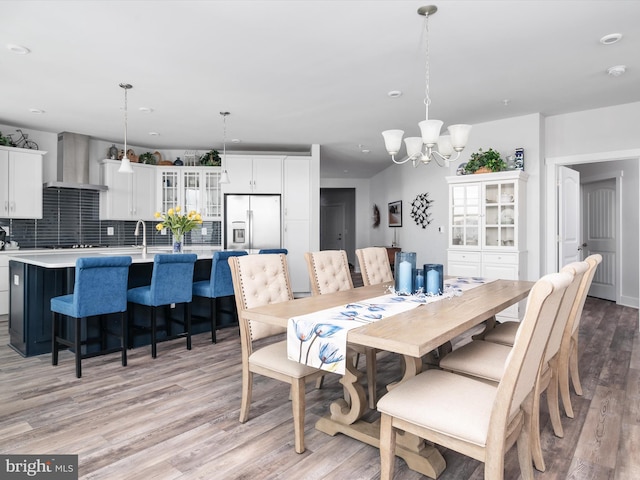 dining space with light wood-style floors and an inviting chandelier