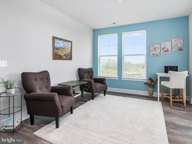 sitting room featuring baseboards, visible vents, and wood finished floors