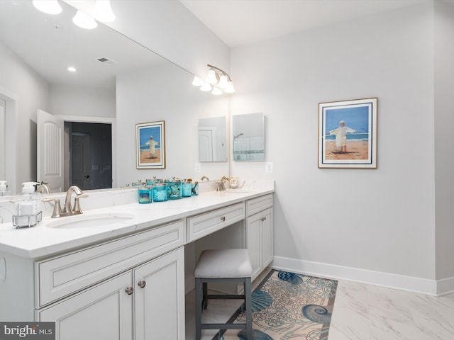 full bath featuring double vanity, baseboards, and a sink