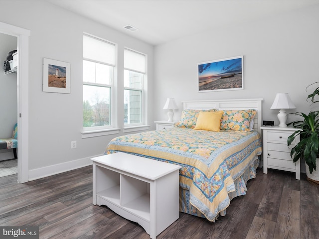 bedroom featuring baseboards, visible vents, and dark wood finished floors