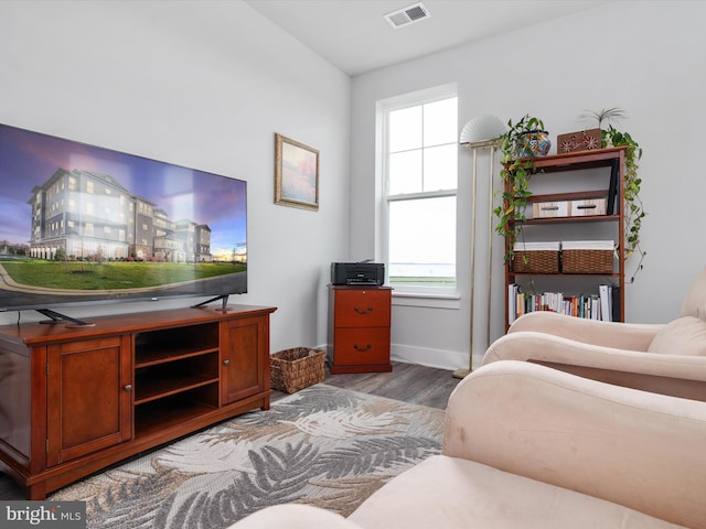 bedroom with baseboards, visible vents, and wood finished floors