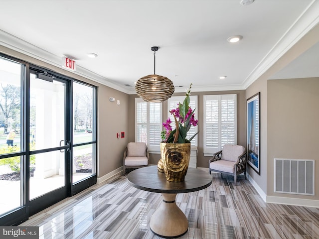 sitting room featuring baseboards, visible vents, and crown molding