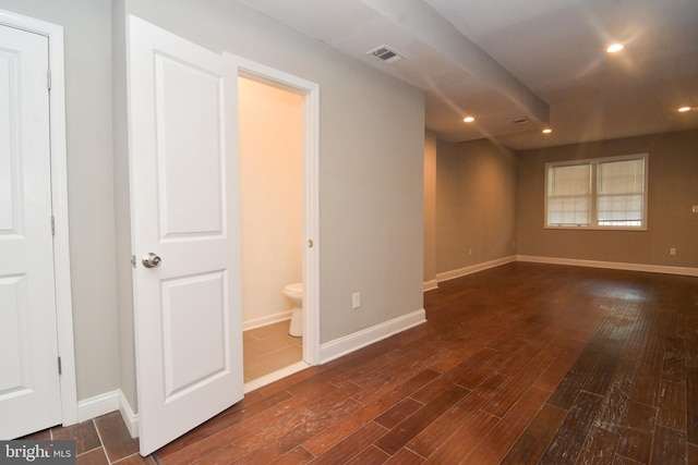 empty room with dark wood-type flooring, recessed lighting, visible vents, and baseboards