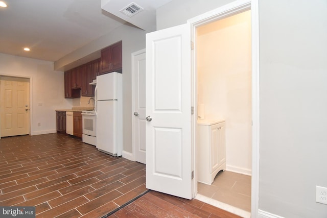 kitchen featuring visible vents, baseboards, light countertops, dark wood-style floors, and white appliances