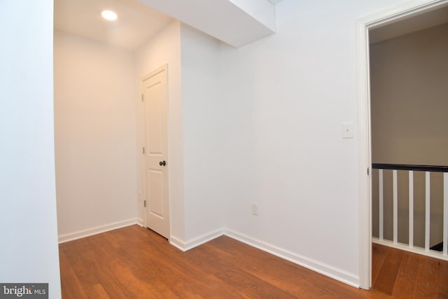 unfurnished room featuring recessed lighting, wood finished floors, and baseboards