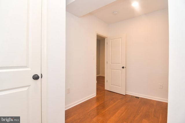 empty room featuring visible vents, baseboards, and wood finished floors