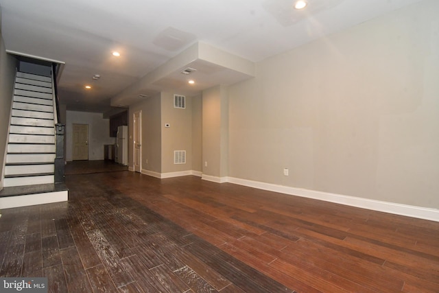 unfurnished living room featuring visible vents, baseboards, dark wood-type flooring, and stairway