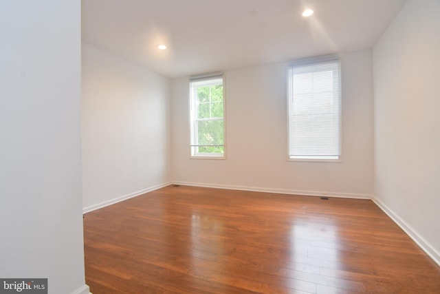 unfurnished room with recessed lighting, baseboards, and wood finished floors