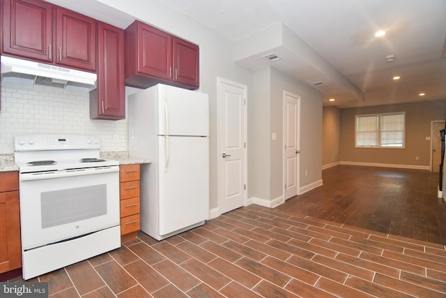 kitchen with white appliances, visible vents, dark wood-type flooring, under cabinet range hood, and tasteful backsplash