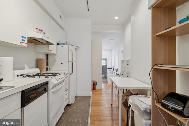 kitchen with white appliances, wood finished floors, light countertops, white cabinetry, and recessed lighting