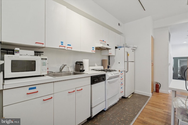 kitchen featuring white appliances, a sink, white cabinets, light countertops, and light wood-type flooring