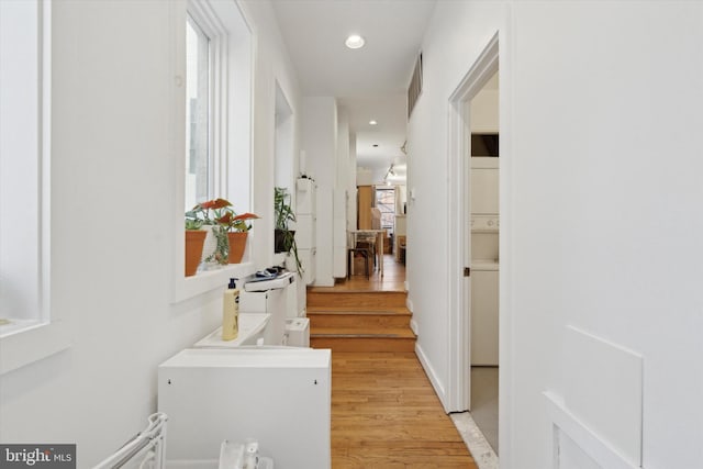 corridor featuring light wood-type flooring, visible vents, and recessed lighting