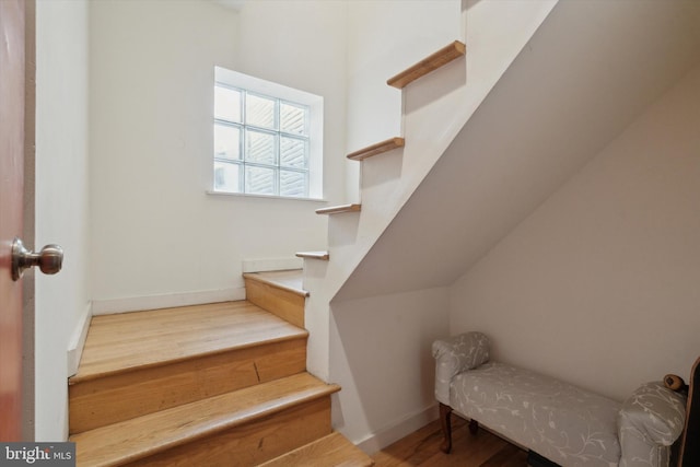 stairway with baseboards and wood finished floors