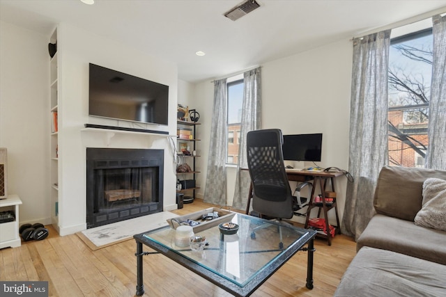 living area featuring a fireplace, visible vents, wood finished floors, and recessed lighting