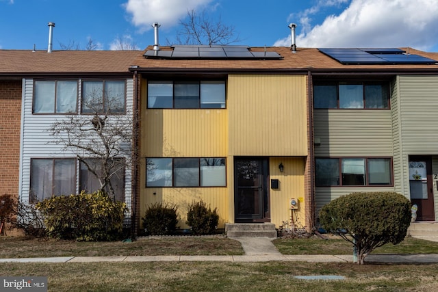 view of front facade featuring roof mounted solar panels