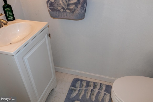 bathroom featuring toilet, tile patterned floors, vanity, and baseboards