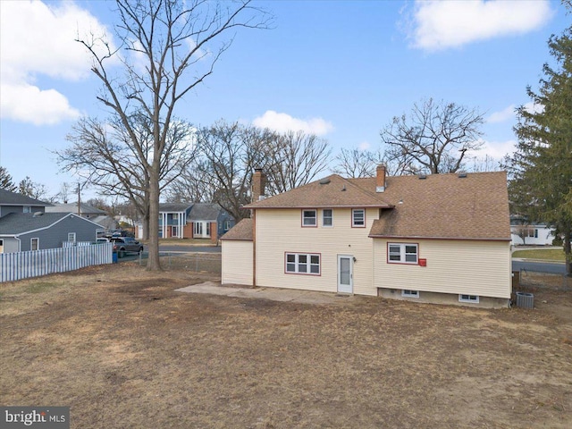 rear view of house with central air condition unit, a residential view, and fence