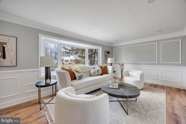 living area with a decorative wall and crown molding