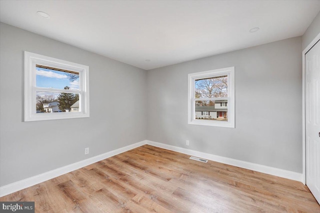 unfurnished room with plenty of natural light, baseboards, and visible vents