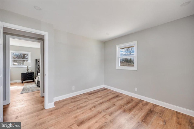 unfurnished room featuring baseboards and light wood-style floors