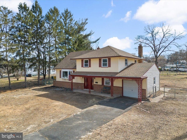 view of front of property featuring driveway, a porch, a garage, brick siding, and a chimney