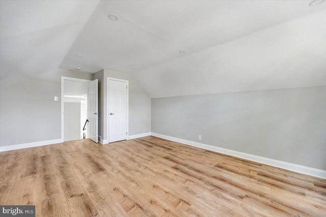 bonus room featuring wood finished floors, baseboards, and vaulted ceiling