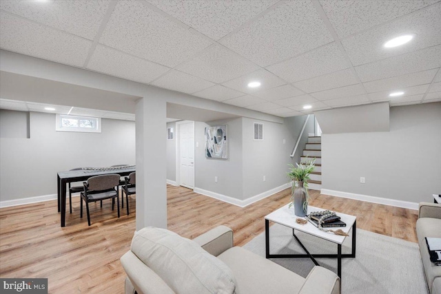 living area featuring stairway, baseboards, visible vents, and wood finished floors