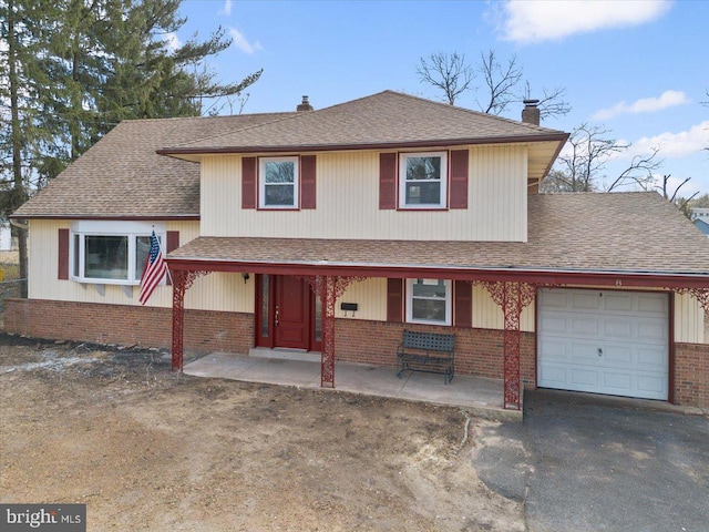 split level home with brick siding, an attached garage, a chimney, and roof with shingles