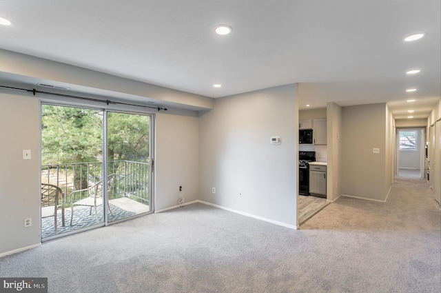 unfurnished living room with recessed lighting, baseboards, and light carpet