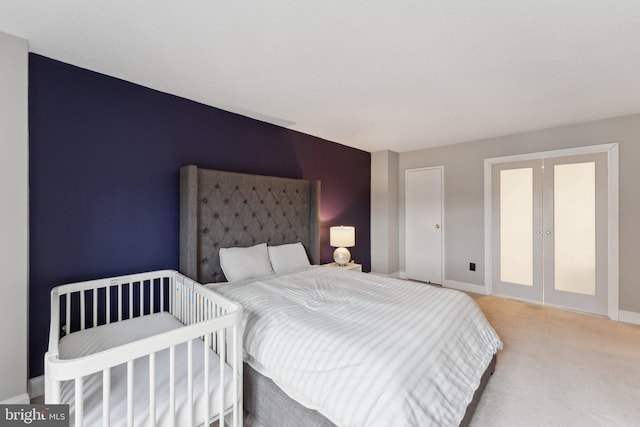 carpeted bedroom featuring french doors and baseboards